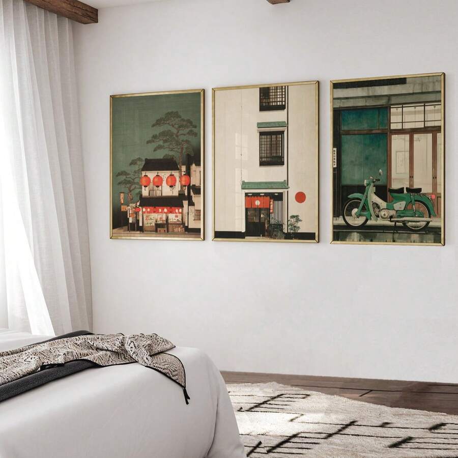 Three framed lantern, townhouse, and motorbike prints above a bedroom