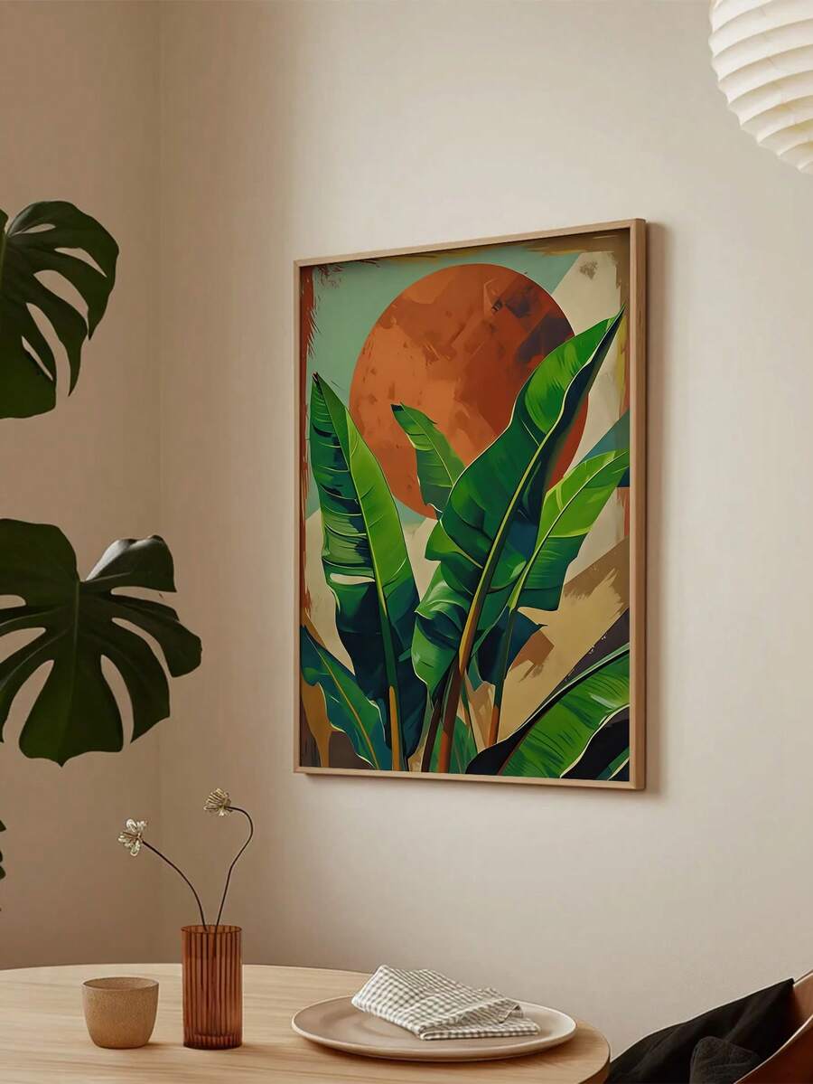 Framed tropical leaf artwork with an orange sun above a dining table