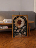Vintage celestial sun and crescent moon canvas poster displayed beside a sofa