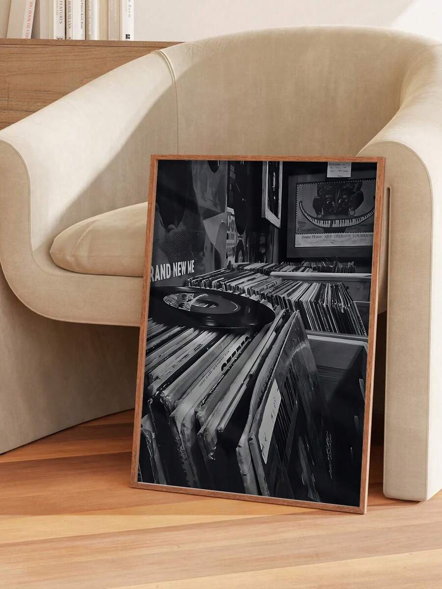 Framed monochrome print showing a vinyl record above rows of albums in a record shop