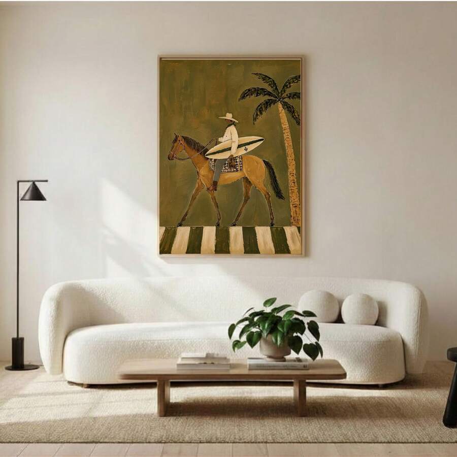Framed coastal canvas showing a surfer carrying board on chestnut horse beneath palm tree above a neutral sofa