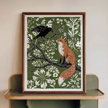 Framed fox and crow folk art poster with cream wildflowers on moss green