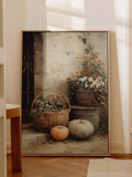 Large framed pumpkin and flower still life leaning on a sunlit cream wall