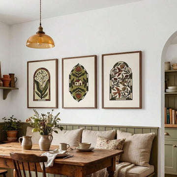Three stained-glass-style botanical prints above a neutral dining banquette
