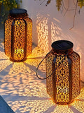 Solar hanging lantern with Moroccan bronze cutout shade and warm shadow pattern