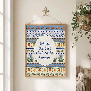 Framed positive quote embroidery poster hanging beside flowering plant