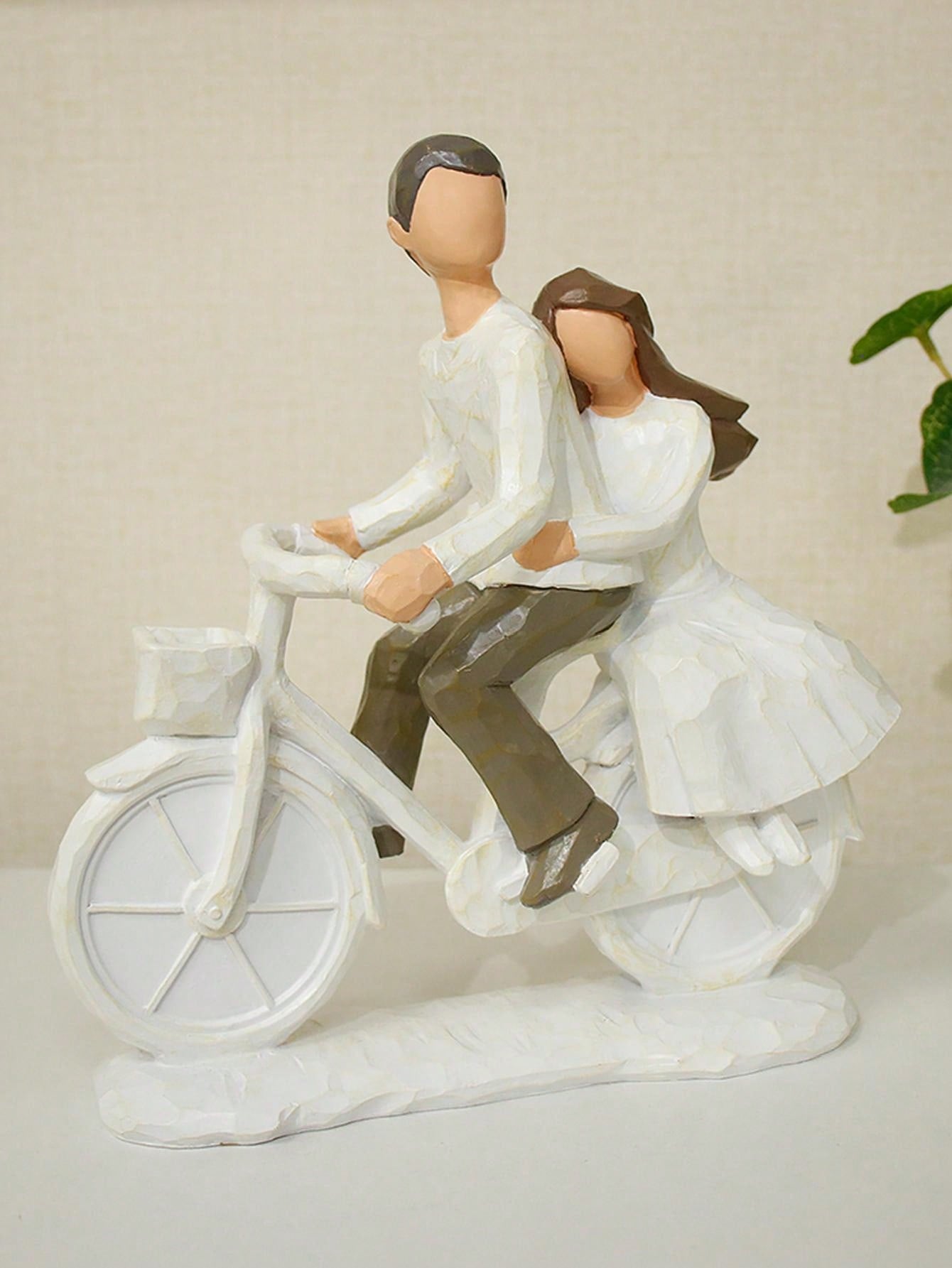This hand-painted romantic cycling couple statue exudes whimsy and charm. The perfect home decor addition, it is also an ideal Valentine's Day gift. Crafted with attention to detail, this statue captures the joy and love shared between two people on a leisurely bike ride. Elevate your space with this enchanting piece.