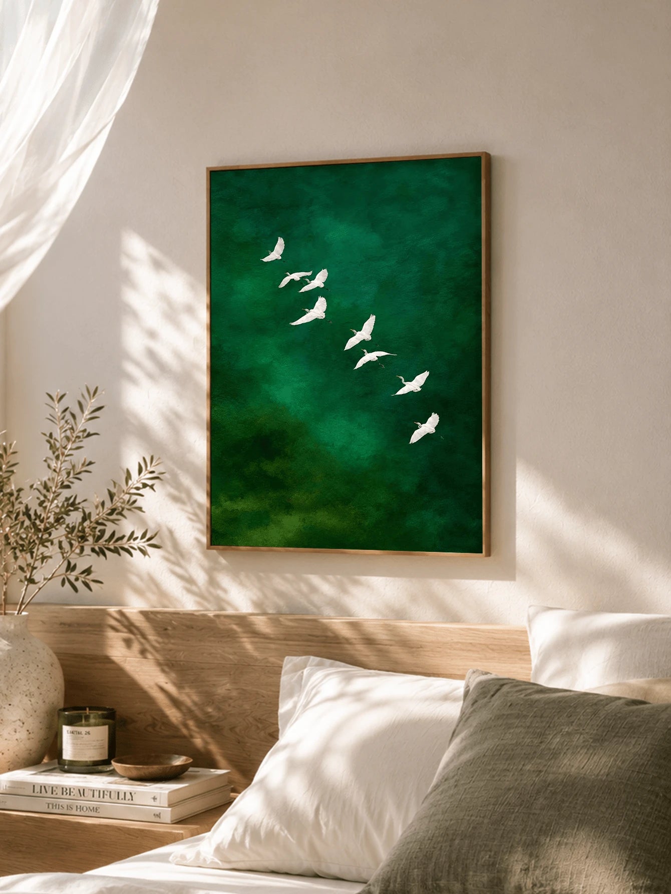 Green watercolor bird wall art above bed in neutral bedroom with sunlight