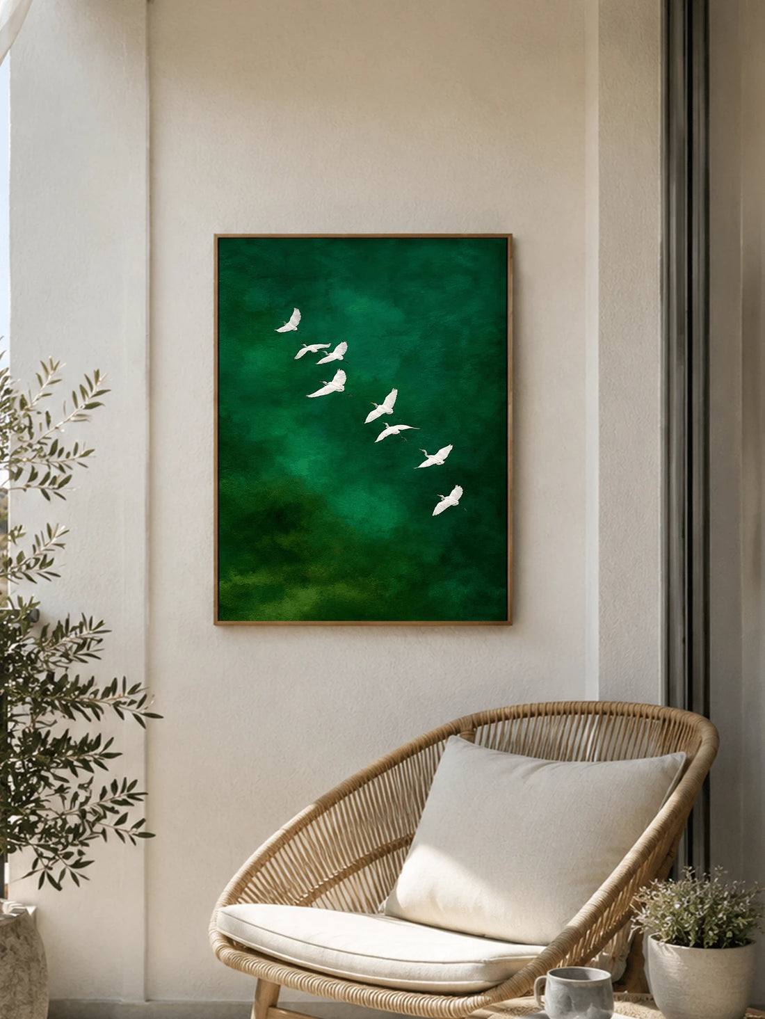 Framed emerald green bird poster with white flying birds above wicker chair